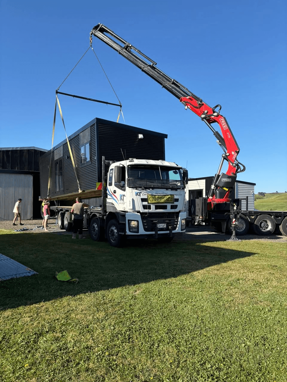 A Smart Housing Solutions tiny home being craned onto a delivery truck